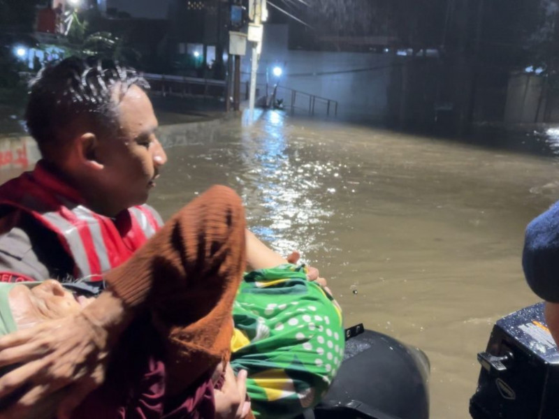 Brimob Metro Jaya Evakuasi Lansia 84 Tahun di Tengah Banjir Pondok Karya
