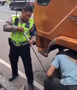 Personel Polantas Bantu Pengemudi Truk Ganti Ban di Jalan Ahmad Yani Bekasi