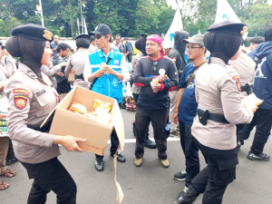 Polri Tunjukan Kepedulian, Polwan Polda Metro Jaya Bagikan Roti dan Air Mineral ke Massa Aksi Buruh di Gambir